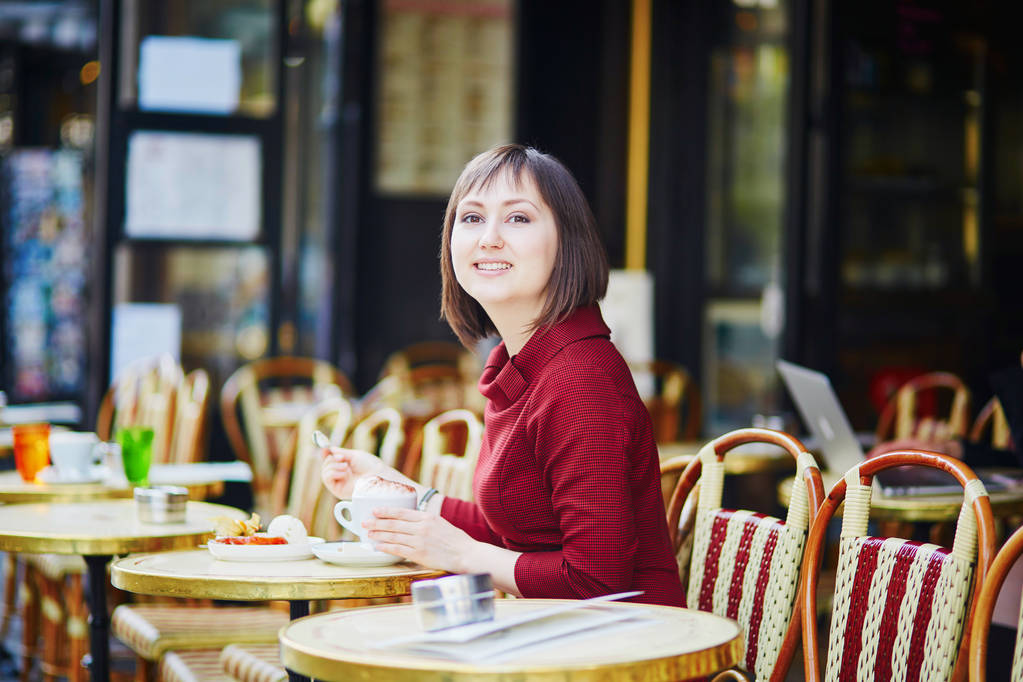 Kaunis ranskalainen nainen juo kahvia ulkona kahvilassa Pariisissa, Ranskassa
 - Valokuva, kuva