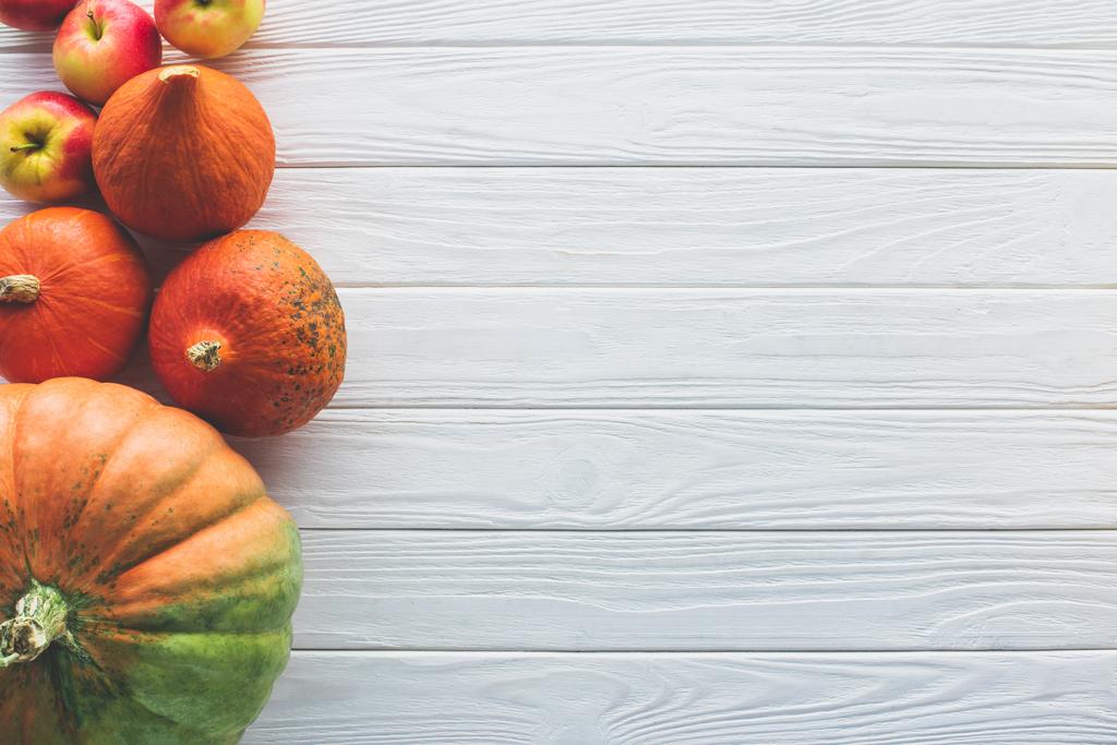 pohled shora podzimní zralé dýně a jablek na dřevěnou desku - Fotografie, Obrázek