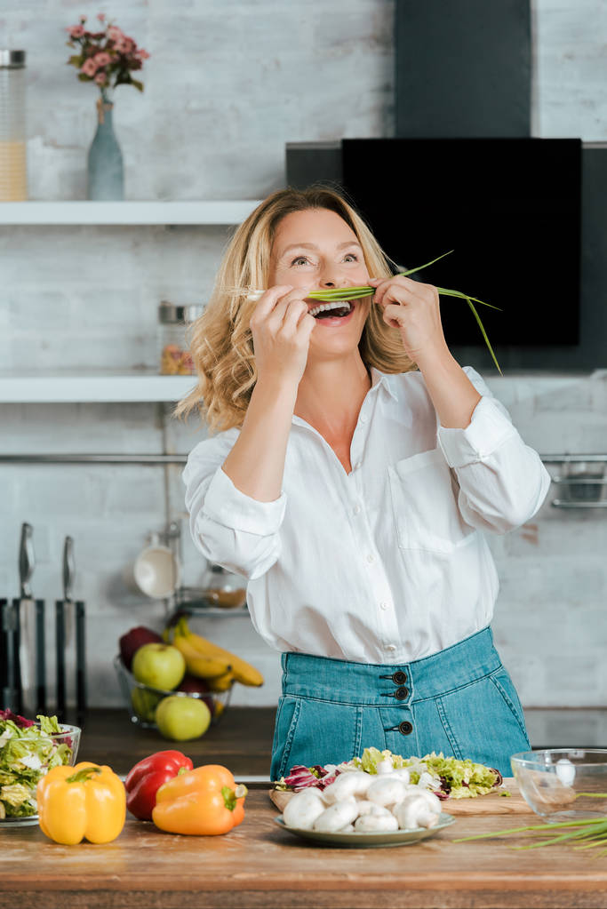 rire femme adulte attachant poireau comme moustache à la cuisine
 - Photo, image