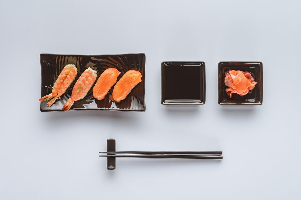 pohled shora gurmánské sushi s lososem a krevetami, zázvor a hůlky izolované na bílém     - Fotografie, Obrázek