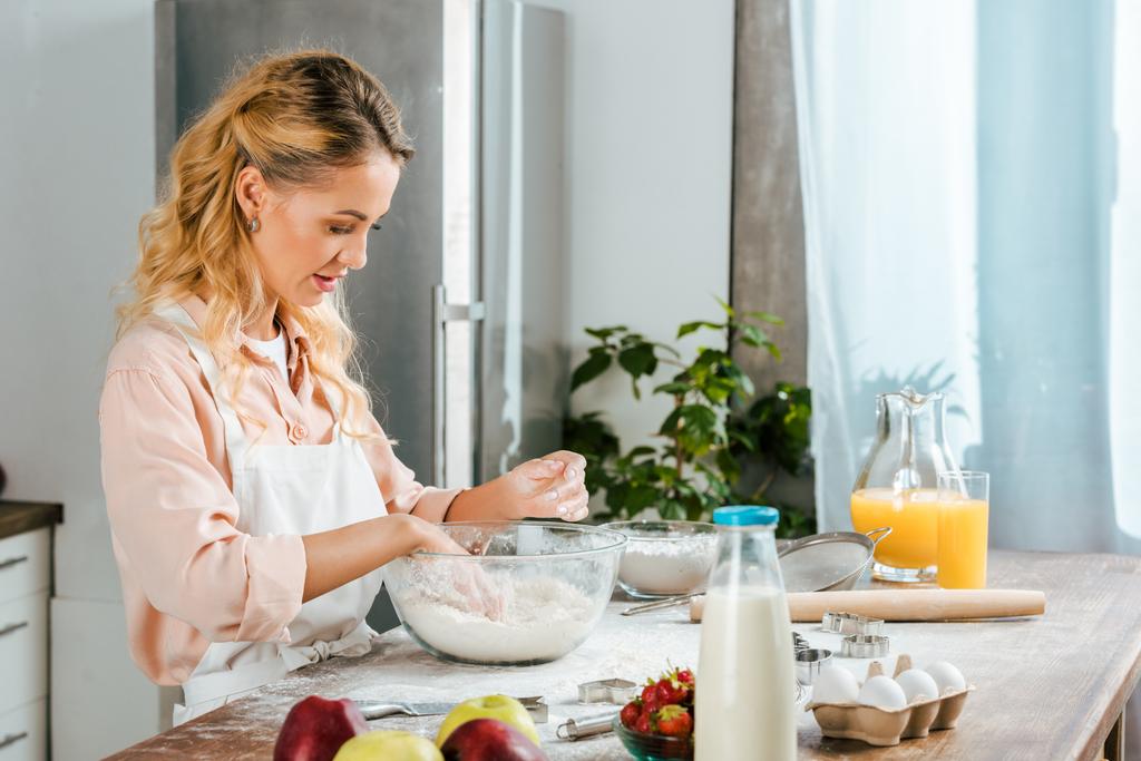 vonzó fiatal nő dagasztása tésztát a tálba, konyha - Fotó, kép