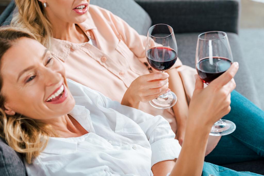 oříznutý snímek zralá matka a dospělé dcery s sklenice červeného vína spolu trávili čas doma - Fotografie, Obrázek