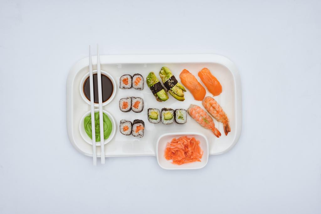 Draufsicht auf Gourmet-Sushi-Set mit Stäbchen isoliert auf weiß  - Foto, Bild