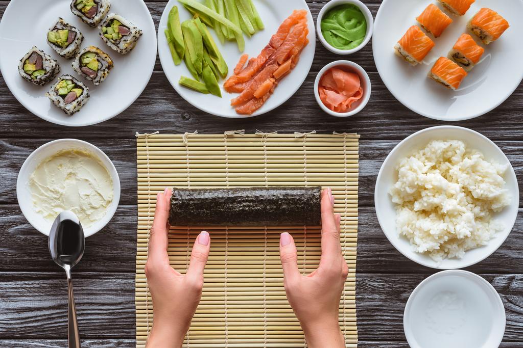 przycięte strzał osoby przygotowuje pyszne sushi roll - Zdjęcie, obraz