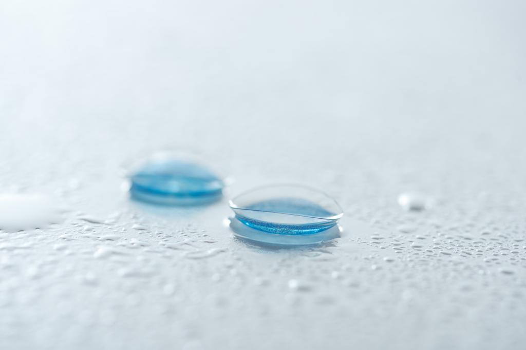 vue rapprochée des lentilles de contact sur fond blanc avec gouttes d'eau
 - Photo, image