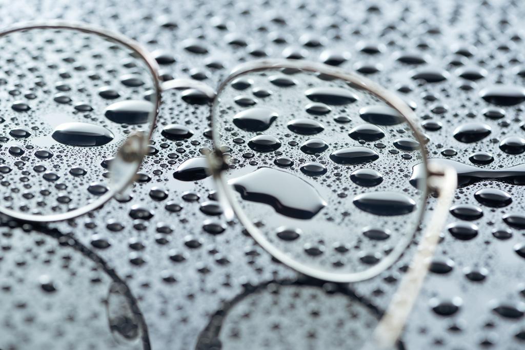 крупним планом окуляри та краплі води на сірому фоні
 - Фото, зображення