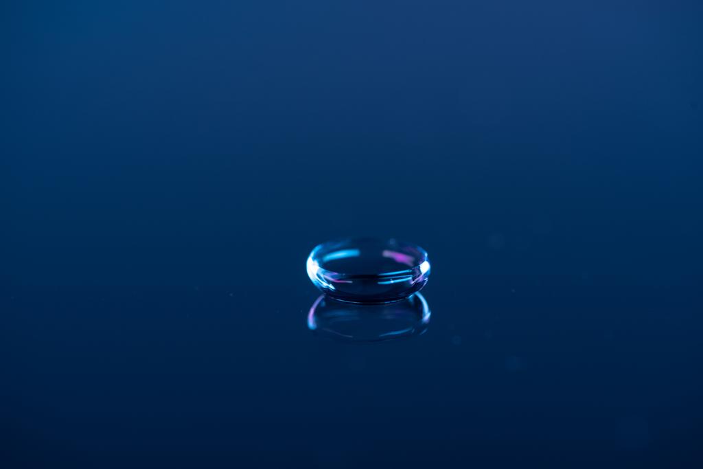 Kontakt lens bakış mavi zemin üzerinde kapatın - Fotoğraf, Görsel