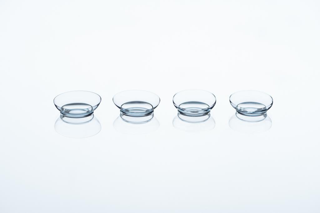 Vista de cerca de las lentes de contacto dispuestas sobre fondo blanco
 - Foto, imagen