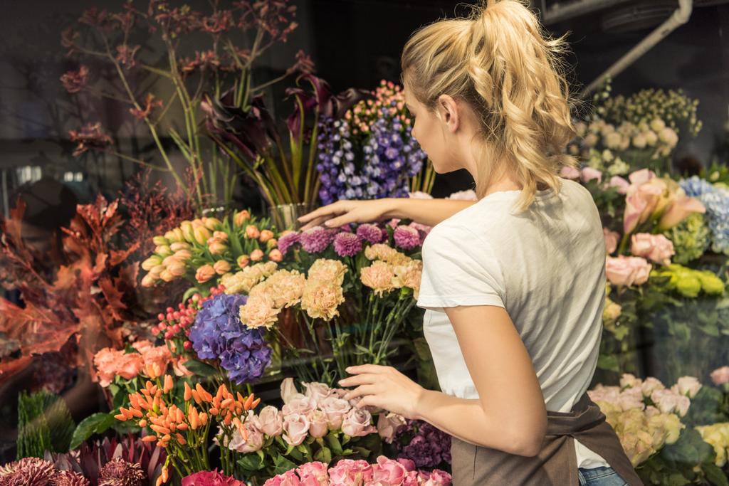 visão traseira do florista cuidando de buquês na loja de flores
 - Foto, Imagem