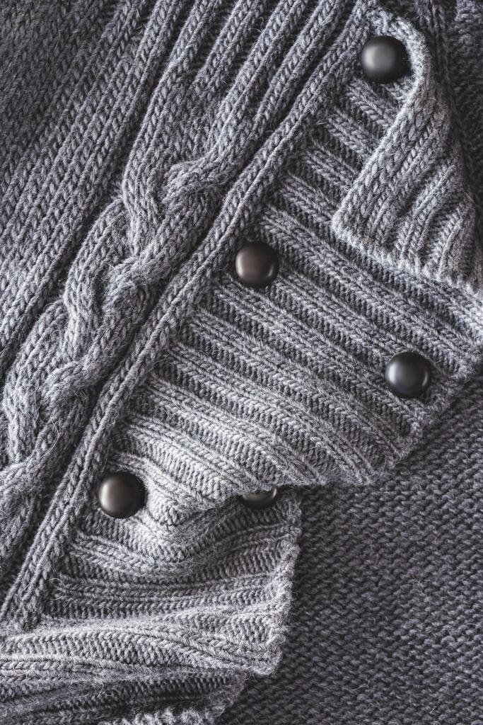 close up view of grey knitted cloth with buttons as backdrop - Photo, Image