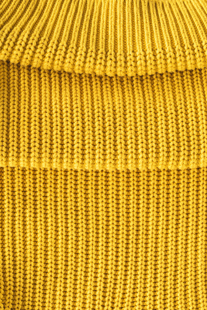 κλείνω πάνω θέα της διπλωμένο φωτεινό κίτρινο μάλλινο ύφασμα ως σκηνικό - Φωτογραφία, εικόνα