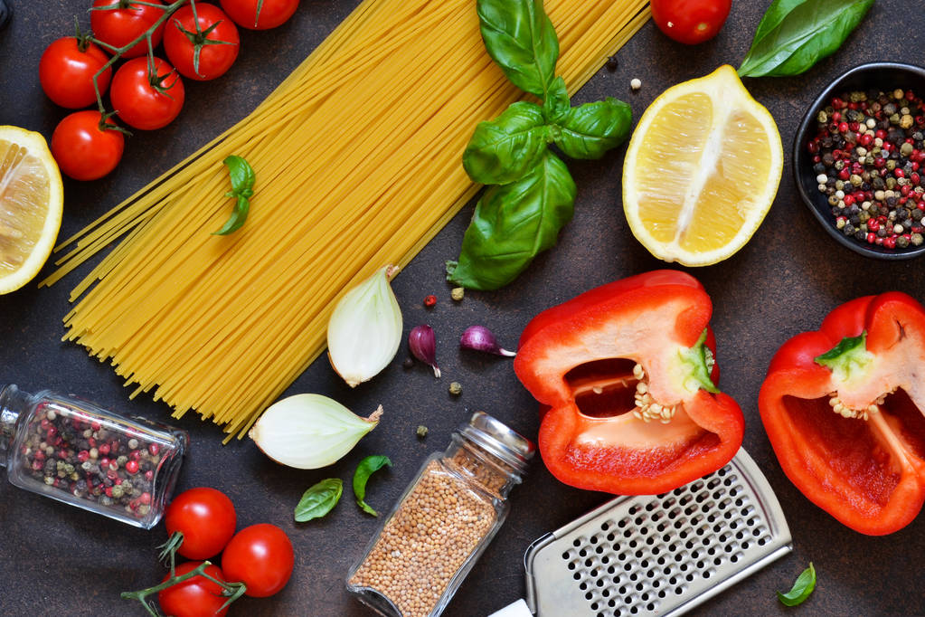 Cibo italiano sfondo. Ingredienti per la cottura della pasta: spaghetti, pomodoro, basilico e pepe su fondo di cemento scuro
. - Foto, immagini