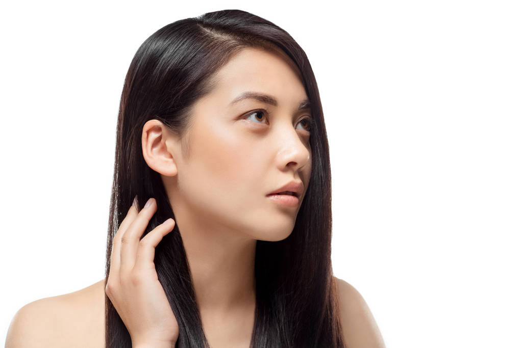 πορτρέτο του συλλογισμένος ασιατικό μοντέλο με δυνατά και υγιή μαλλιά που αναζητούν μακριά απομονωθεί σε λευκό - Φωτογραφία, εικόνα