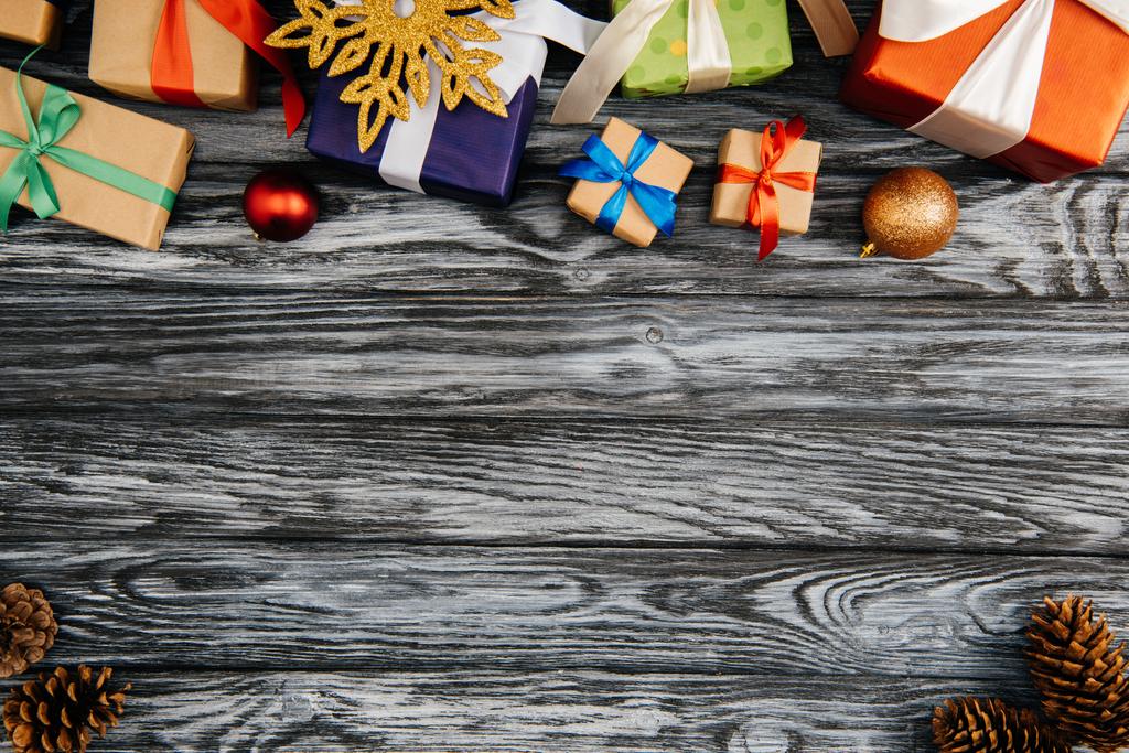 bovenaanzicht van geschenkdozen en kerstversiering op houten oppervlak - Foto, afbeelding