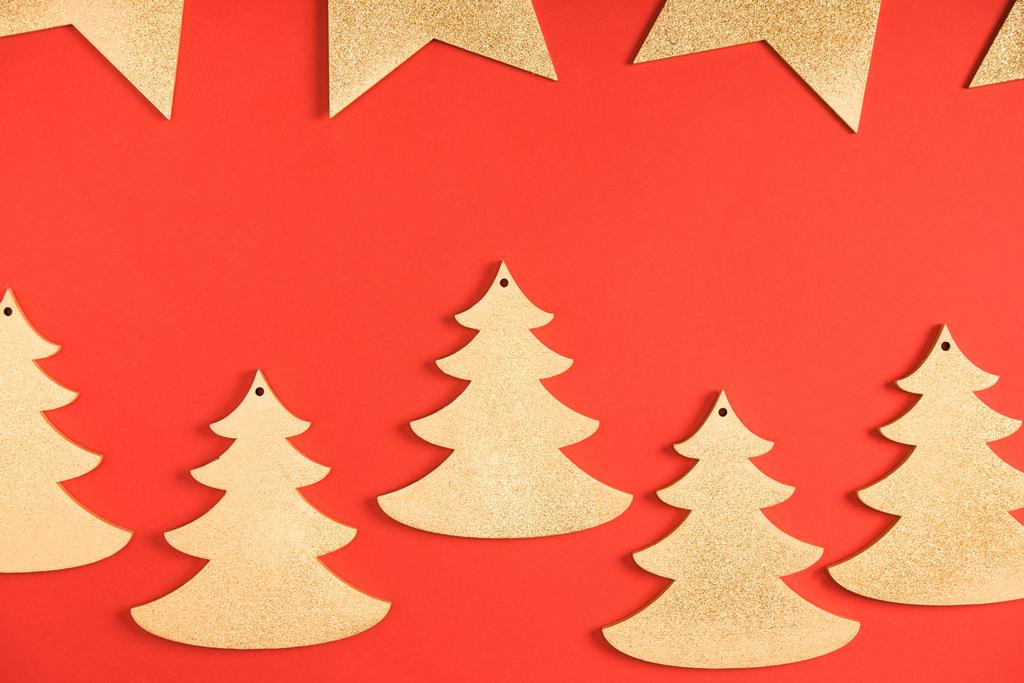 felülnézet arany csillag és fenyő fa szimbólumok, piros háttér - Fotó, kép