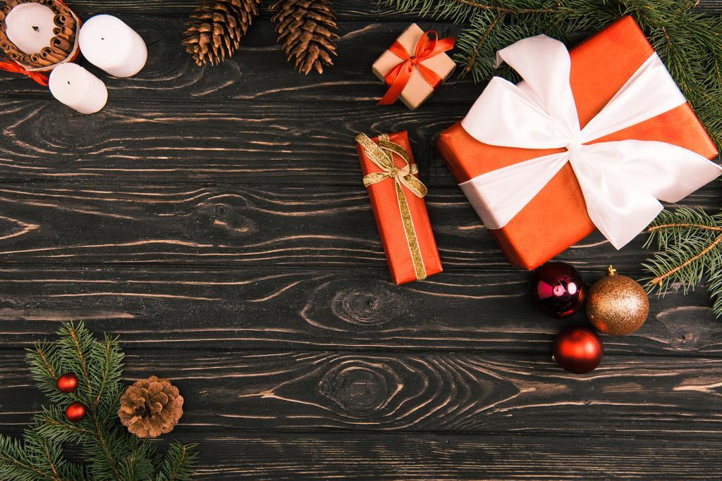 вид зверху на подарункові коробки, різдвяні кульки та ялинкові гілки на дерев'яній поверхні
 - Фото, зображення