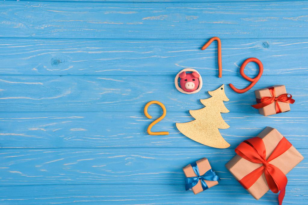 bovenaanzicht van geschenkdozen en 2019 symbool op blauwe houten oppervlak - Foto, afbeelding