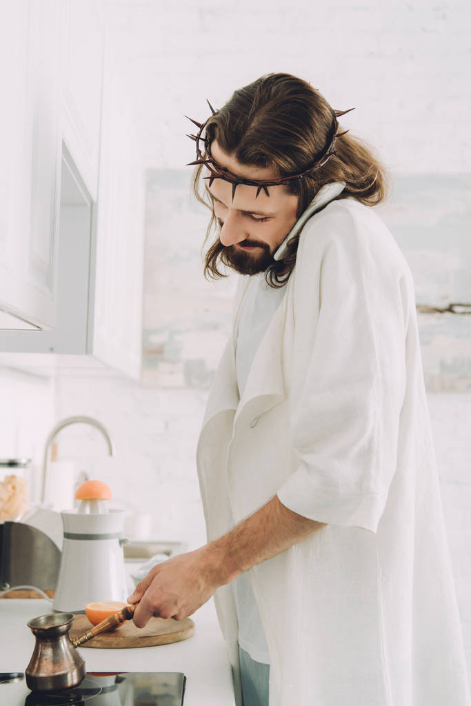 スマート フォンで話して、朝時に自宅の台所で cezve コーヒーを作るイエスの選択と集中  - 写真・画像