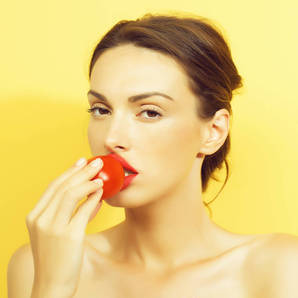 mooi meisje met rode tomaat - Foto, afbeelding