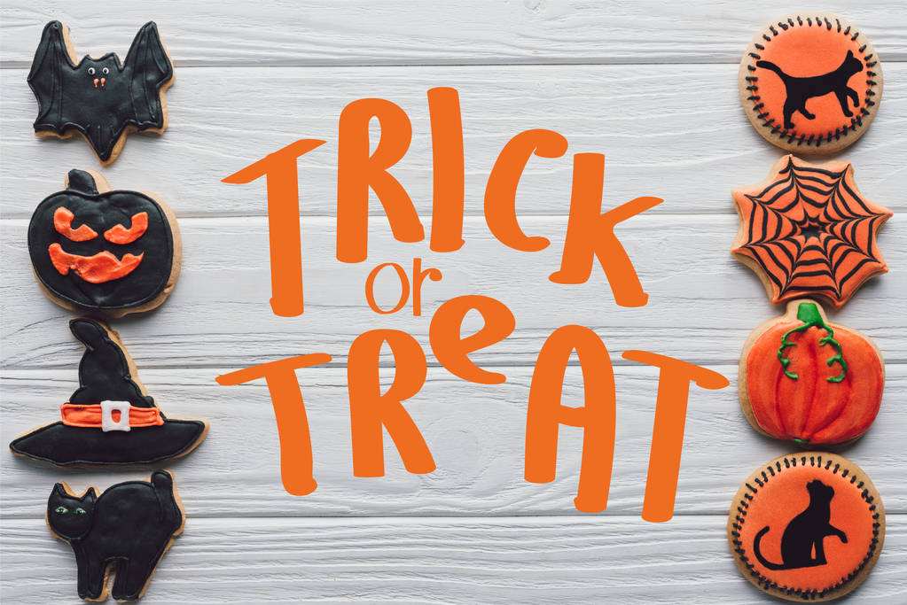 elevated view of arranged homemade halloween cookies placed in rows on white wooden background  with "trick or treat" lettering - Photo, Image