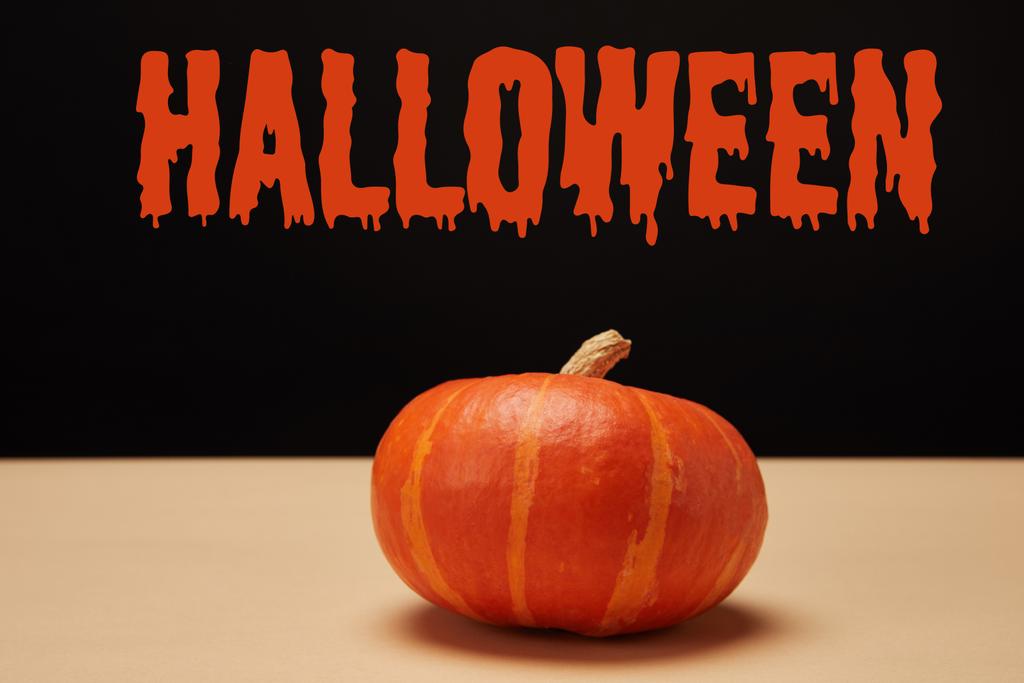 one orange pumpkin on table with "halloween" lettering - Photo, Image