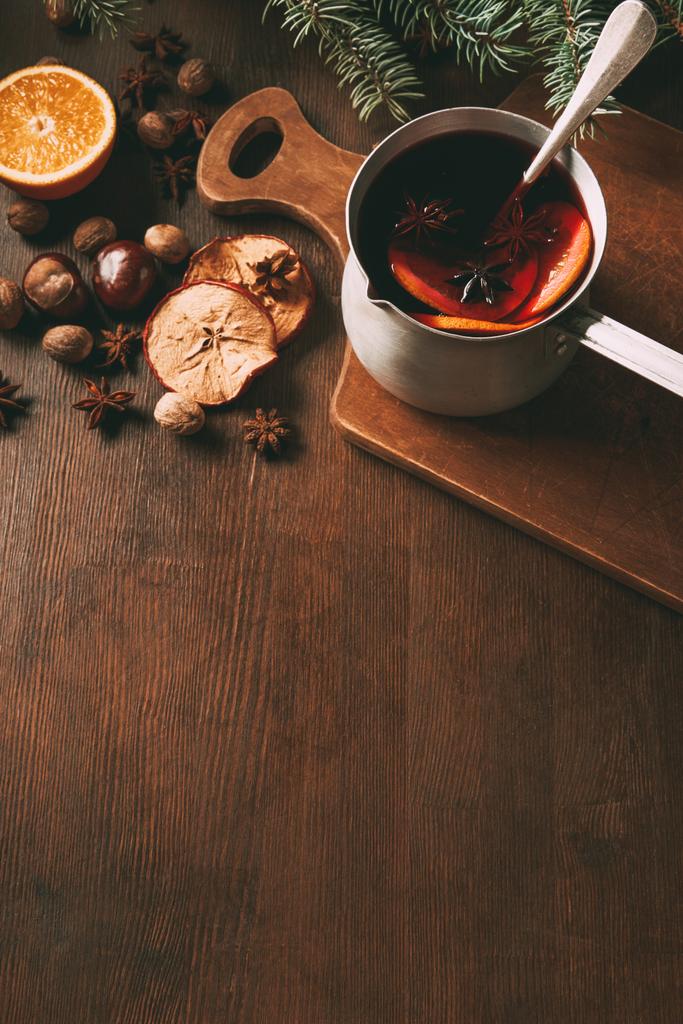 vinho picado quente em panela com especiarias de Natal em fundo de madeira
 - Foto, Imagem