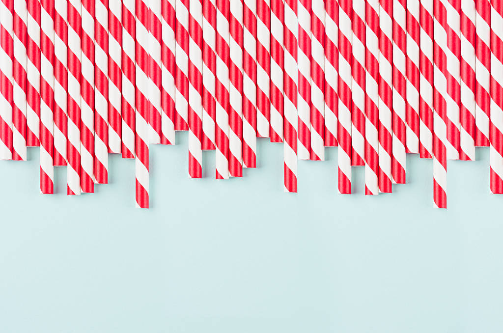 Abstract modern fashion background - red and white striped straws as border pattern on light mint background. - Photo, Image