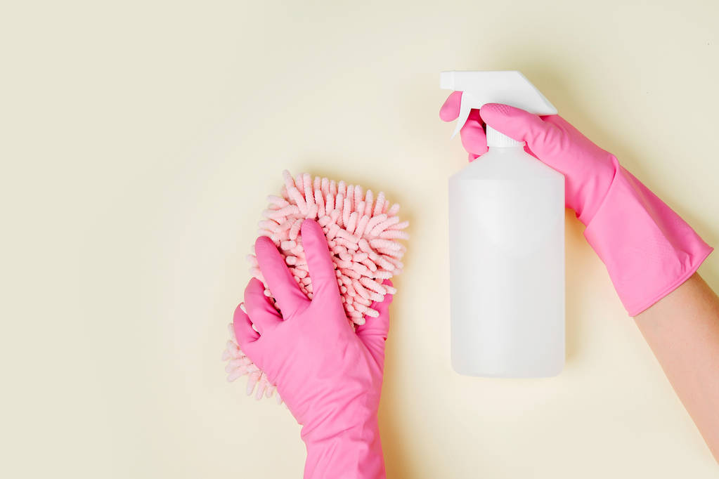 mani in guanti di gomma che tengono spray detergente e spugna
  - Foto, immagini