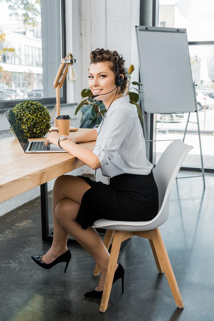 jonge vrouwelijke center operator met headset aandoen met werkplek op kantoor - Foto, afbeelding