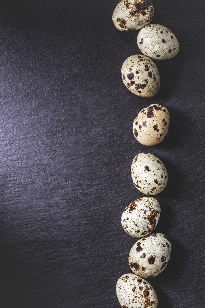 vista dall'alto di uova di quaglia crude biologiche sane su sfondo nero
 - Foto, immagini