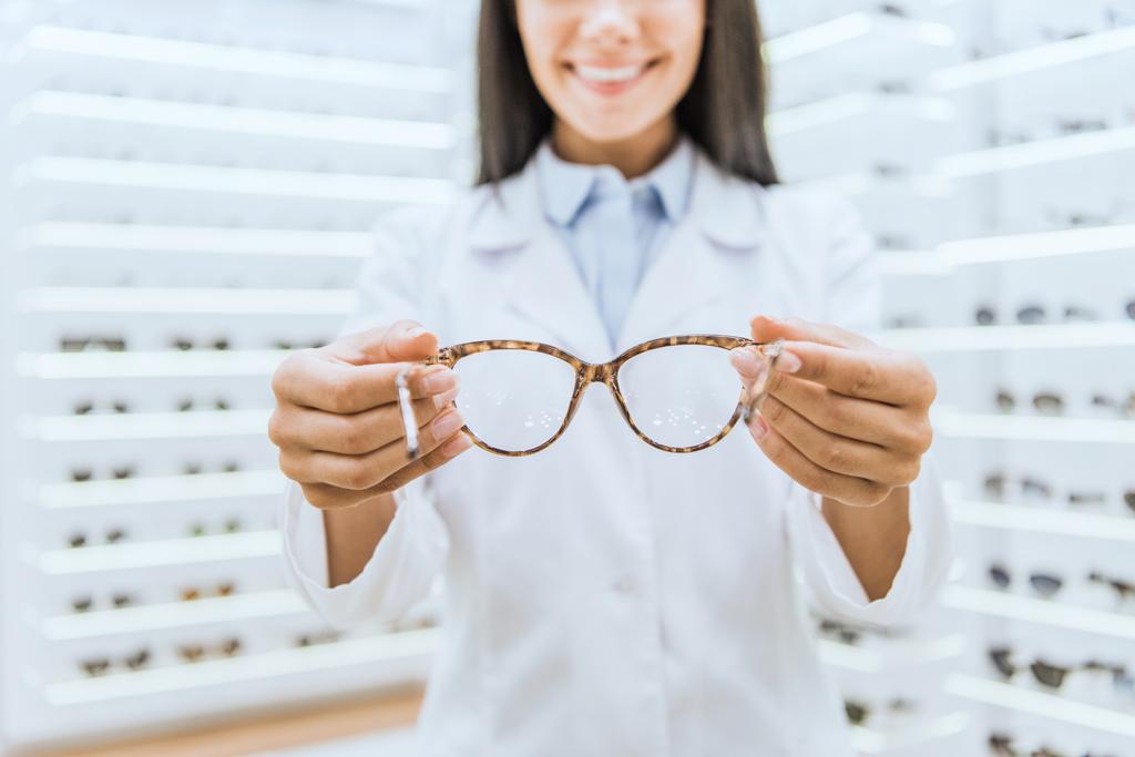 vue recadrée de l'optométriste professionnel tenant des lunettes
 - Photo, image