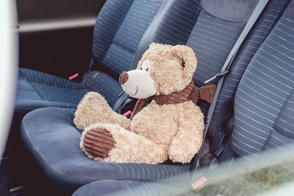 κοντινή λήψη ενός χαριτωμένο αρκουδάκι που κάθεται στο πίσω καθίσματα του αυτοκινήτου - Φωτογραφία, εικόνα