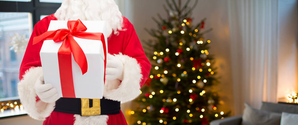 Papai Noel com presente de Natal sobre quarto
 - Foto, Imagem