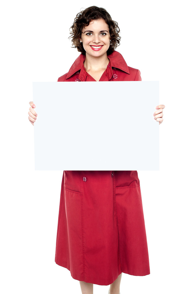mujer con un abrigo rojo mostrando letrero en blanco
 - Foto, imagen