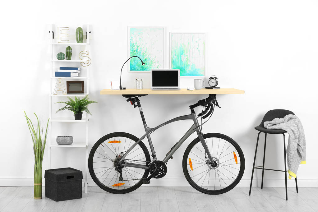 Современный интерьер домашнего офиса с велосипедом возле стены
 - Фото, изображение