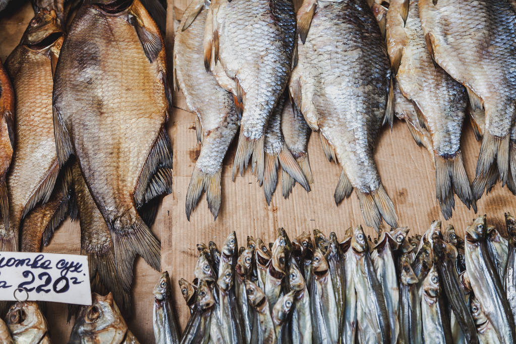 Halsorozat a bazárban. Különböző fajtájú szárított halak sorai fekszenek a pulton a márkában. - Fotó, kép