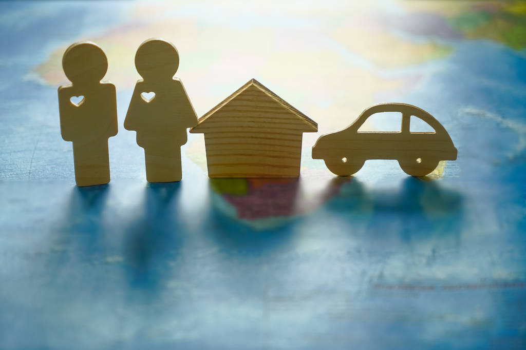 wooden figures - couple, house, car on paper world map.  - Photo, Image