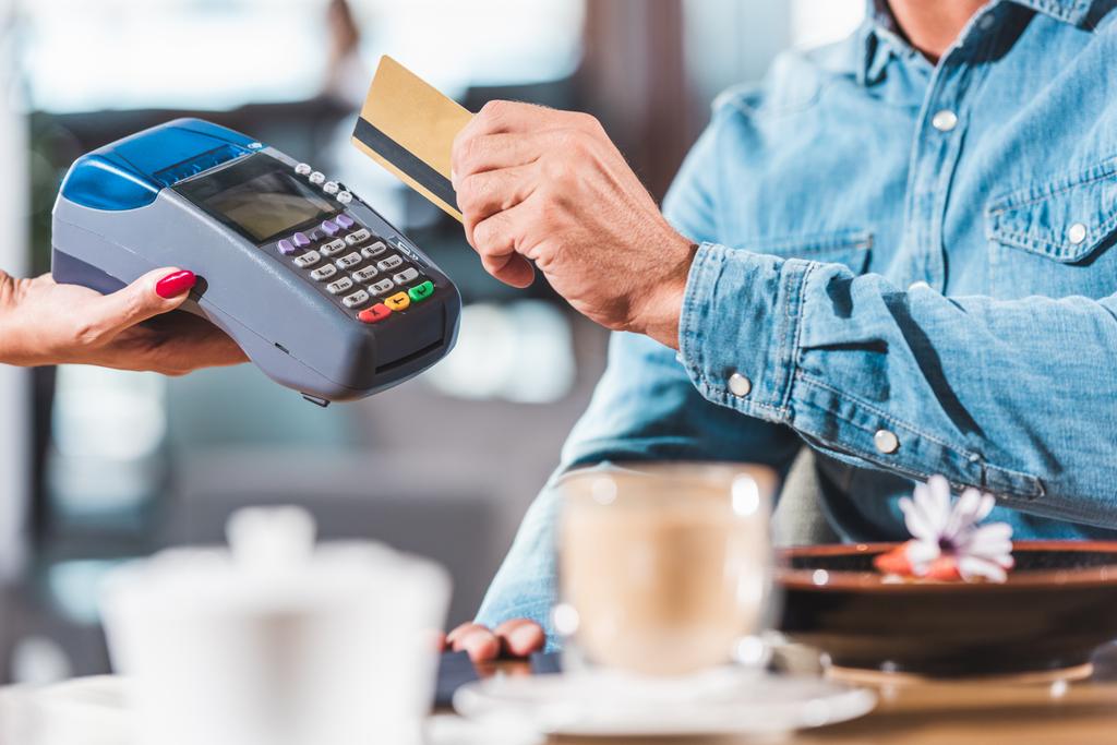 περικομμένη εικόνα του ανθρώπου που πληρώνουν με πιστωτική κάρτα σε καφετέρια - Φωτογραφία, εικόνα