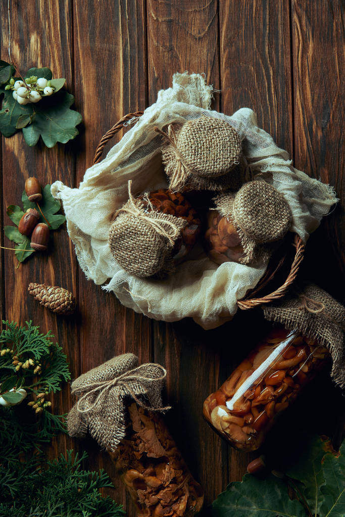 vista superior de deliciosos cogumelos em conserva na cesta na mesa de madeira
  - Foto, Imagem
