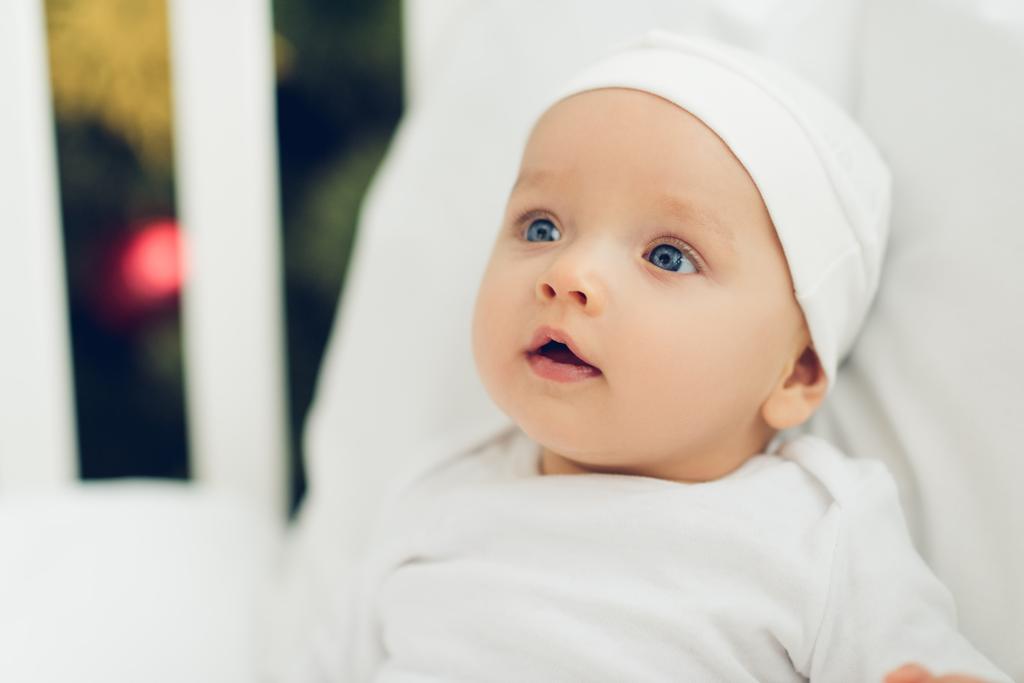 愛らしい赤ちゃんの白い帽子がよそ見でクローズ アップの肖像画 - 写真・画像