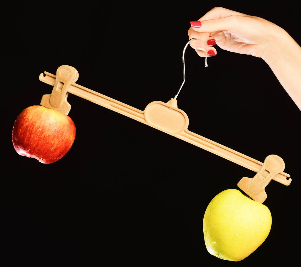 Zöld és piros színű alma egyenlőtlen súllyal. - Fotó, kép
