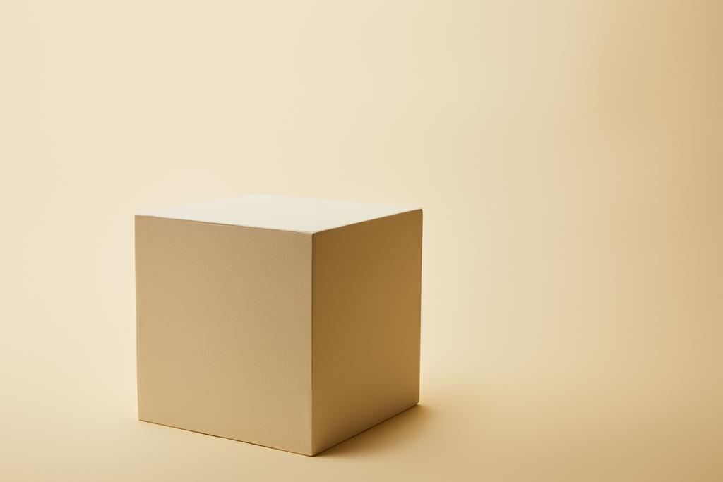 Close-up shot van enkele kubus op beige oppervlak - Foto, afbeelding