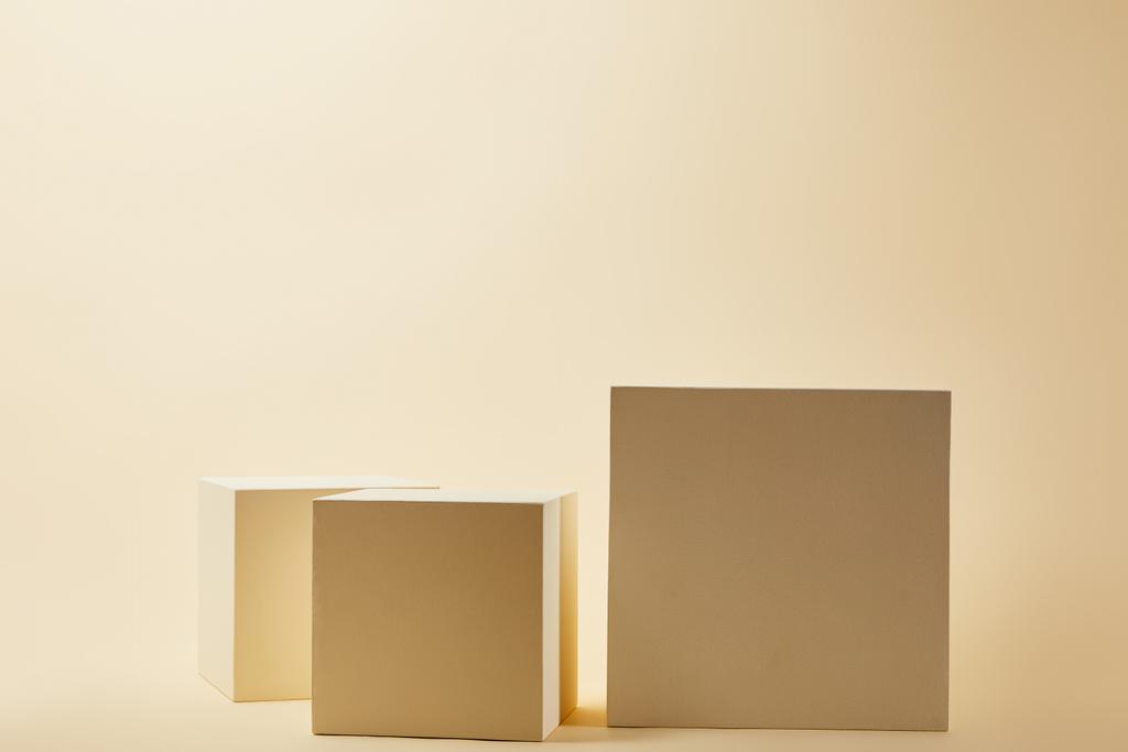 натюрморт кубиков различных размеров на бежевой поверхности
 - Фото, изображение