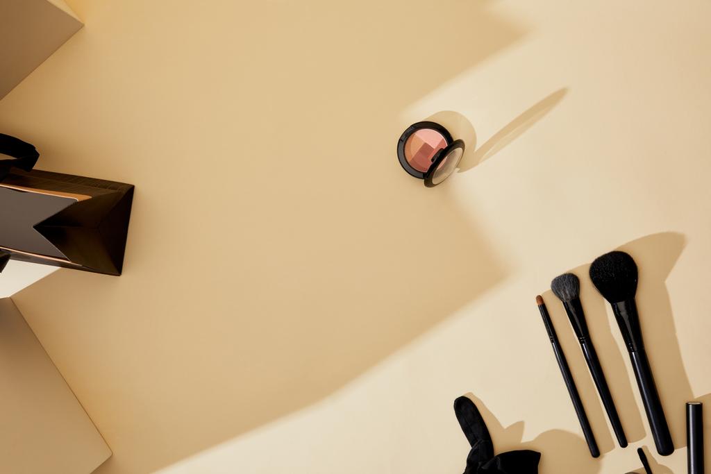 vista superior de los suministros de maquillaje acostado en la mesa de color beige
 - Foto, imagen