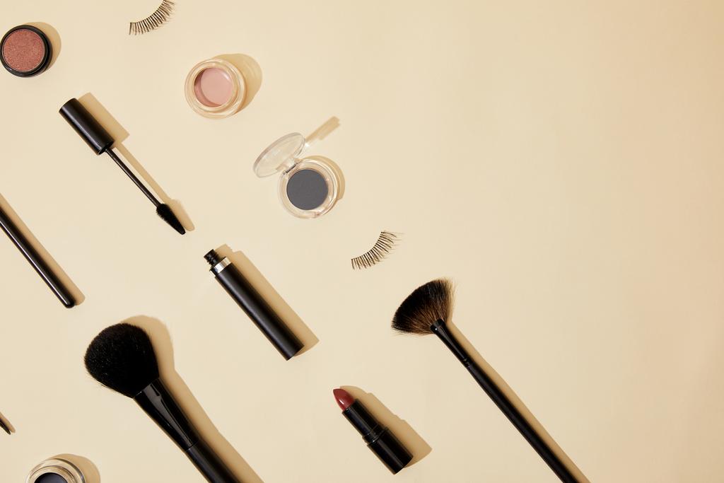 flat lay with composition of different cosmetics lying on beige tabletop - Photo, Image