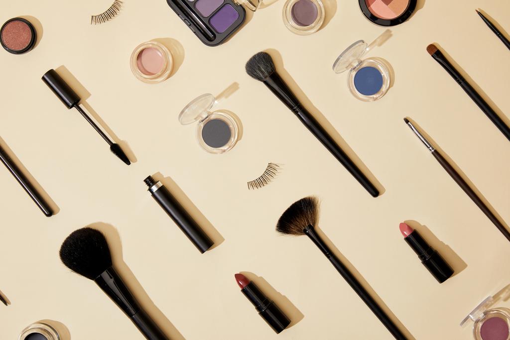 top view of composition of different cosmetics lying on beige surface - Photo, Image