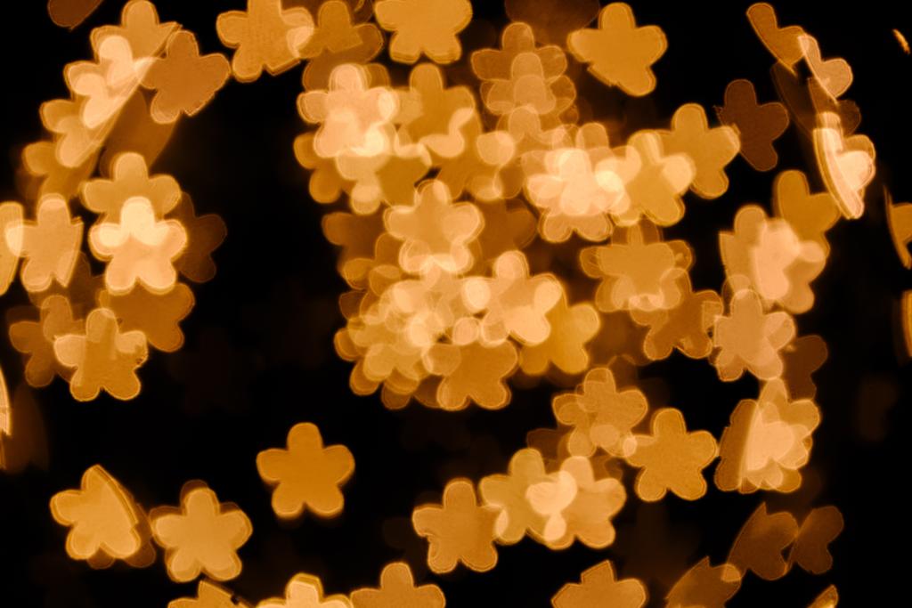 lähikuva kultaisista tähdistä bokeh valot mustalla taustalla
 - Valokuva, kuva