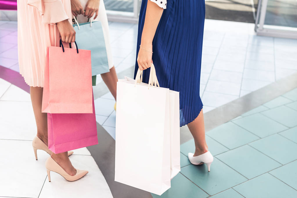 Schnappschuss stilvoller Mädchen mit Papiertüten in Einkaufszentrum - Foto, Bild