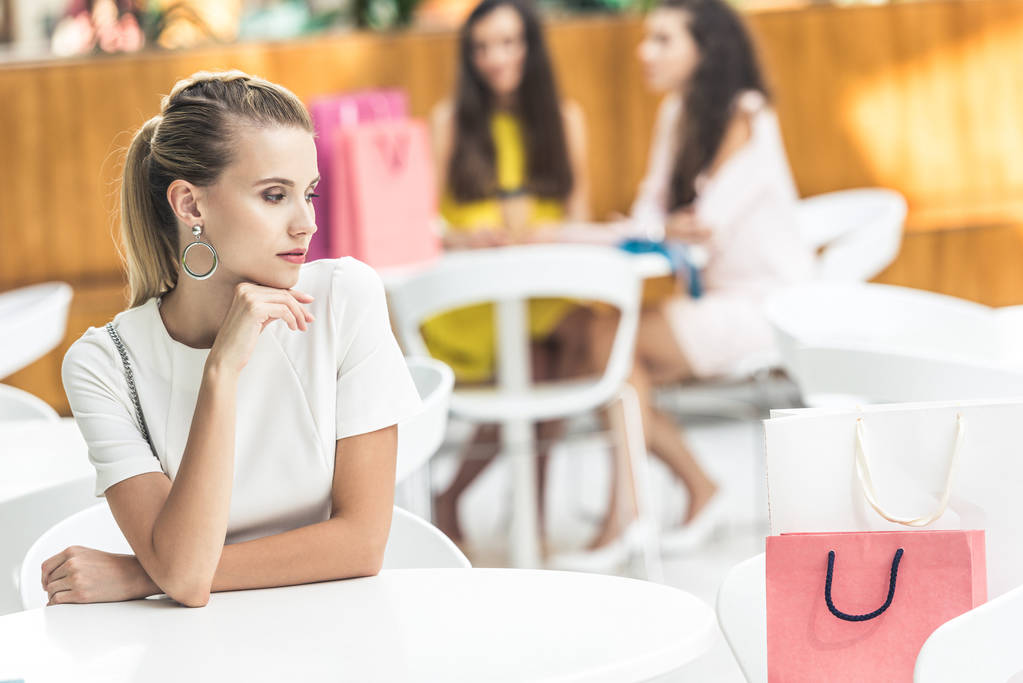 jovem mulher pensativo sentado à mesa e olhando para longe no café no shopping
 - Foto, Imagem