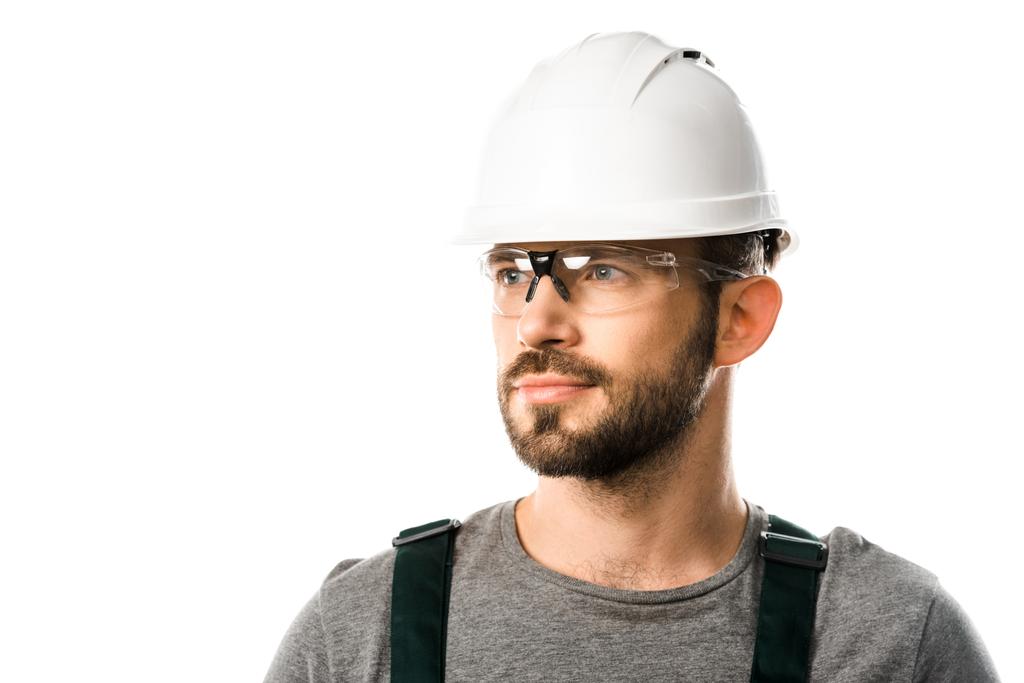портрет красивого водопроводчика в шлеме и защитных очках, смотрящего в сторону изолированного на белом
 - Фото, изображение
